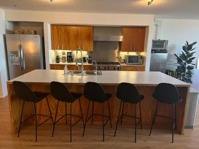 a kitchen with a kitchen island with four chairs around it at STAY OPEN Venice Beach in Los Angeles