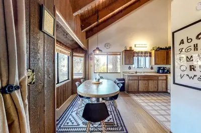 a room with a table and a kitchen at Grey Stone Fire in Running Springs