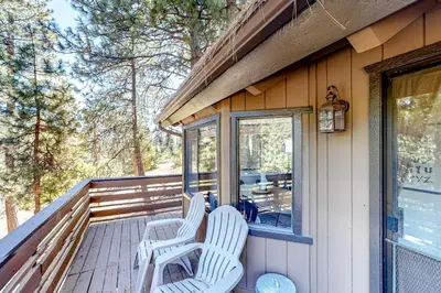 two white chairs sitting on the front porch of a house at Grey Stone Fire in Running Springs