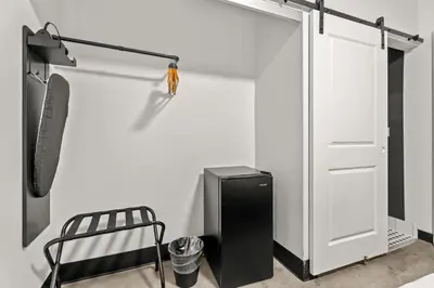 a room with a white wall and a door and a chair at Hollywood Le Bon Hotel in Los Angeles