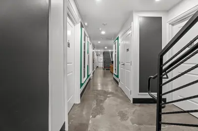 a hallway with green and white walls and a staircase at Hollywood Le Bon Hotel in Los Angeles