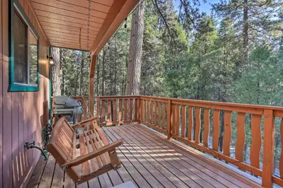 a wooden deck with a bench and a grill on it at Cozy Cabin about 3 Mi to Lake Arrowhead Village! in Lake Arrowhead