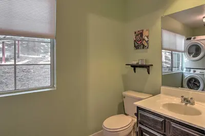 a bathroom with a toilet and a sink and a washing machine at Cozy Cabin about 3 Mi to Lake Arrowhead Village! in Lake Arrowhead