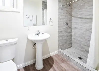 a white bathroom with a sink and a shower at Holly Park Motel near LAX in Inglewood