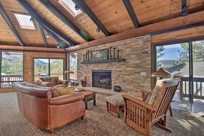 a living room with a couch and a fireplace at Cozy Grand Woodland Cabin with Mountain Views in Pine Mountain Club