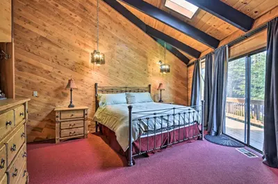 a bedroom with a bed in a room with wooden walls at Cozy Grand Woodland Cabin with Mountain Views in Pine Mountain Club