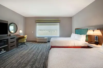 a hotel room with two beds and a desk and a window at Hampton Inn & Suites By Hilton Rancho Cucamonga in Rancho Cucamonga