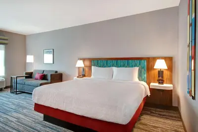 a hotel room with a large bed and a couch at Hampton Inn & Suites By Hilton Rancho Cucamonga in Rancho Cucamonga