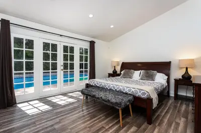 a bedroom with a bed and a swimming pool at Villa Sausalito - Newly Designed 4BR HOUSE & POOL by Topanga in Los Angeles