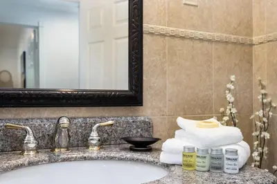 a bathroom with a sink and a mirror and towels at Villa Sausalito - Newly Designed 4BR HOUSE & POOL by Topanga in Los Angeles