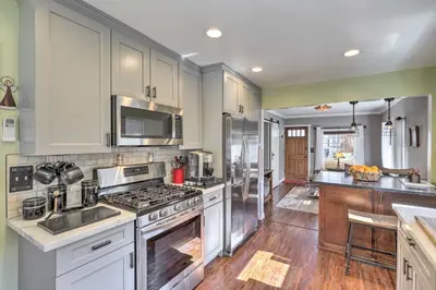 a kitchen with white cabinets and a stove top oven at Charming Craftsman Bungalow with Garden and Hot Tub! in Fullerton
