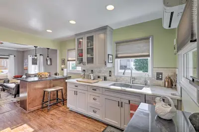 a large kitchen with white cabinets and a sink at Charming Craftsman Bungalow with Garden and Hot Tub! in Fullerton