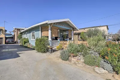 a blue house with a porch and a driveway at Charming Craftsman Bungalow with Garden and Hot Tub! in Fullerton
