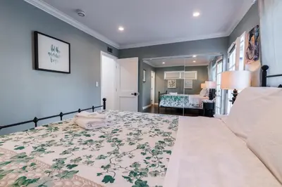 a bedroom with a large bed with a floral bedspread at Le Bleu House - Newly Designed 3BR HOUSE & POOL by Topanga in Los Angeles
