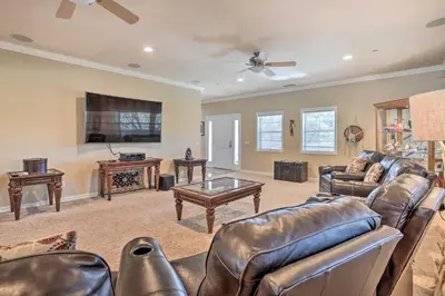 a living room with leather furniture and a flat screen tv at Huge Lake Arrowhead Home with 3 Decks and Grill! in Lake Arrowhead