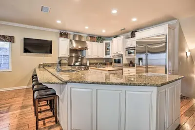 a large kitchen with white cabinets and a large island at Huge Lake Arrowhead Home with 3 Decks and Grill! in Lake Arrowhead