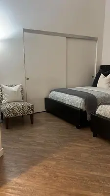 a bedroom with two beds and a chair at Exceptional Loft FREE Parking and WIFI in Los Angeles