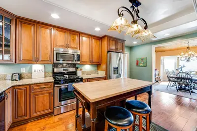 a kitchen with wooden cabinets and a wooden table at Gregory Getaway in Crestline
