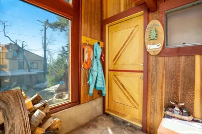 a door to a cabin with a surfboard next to a window at The Valley's Cabin in Green Valley Lake