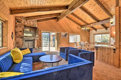 a living room with blue couches and a table at Luxe Escape with Decks, Mtn Views, Game Room! in Frazier Park