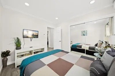 a white bedroom with a bed and a couch at Dreamy & Relaxing Gem With Backyard - 12mins to DT LA in Alhambra