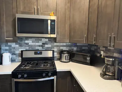 a kitchen with a stove and a microwave at Fruit Hostel in Los Angeles