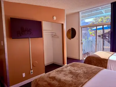 a hotel room with two beds and a window at Foghorn Harbor Inn in Los Angeles