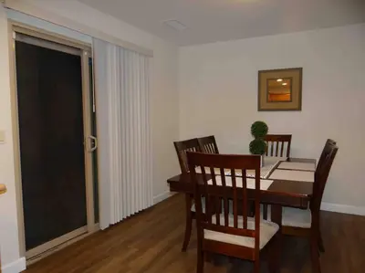 a dining room with a wooden table and chairs at Beautiful and Cozy 4-BR residential home!!! in Oxnard