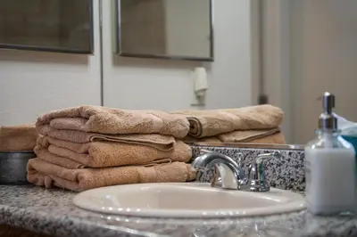 a pile of towels sitting on top of a bathroom sink at Lazy Squirrel - Cozy Family House with Full Game Room in Kernville