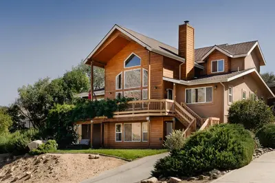 a large house with a porch and a deck at Epic View A Luxury House on a Hill River 10 min in Kernville