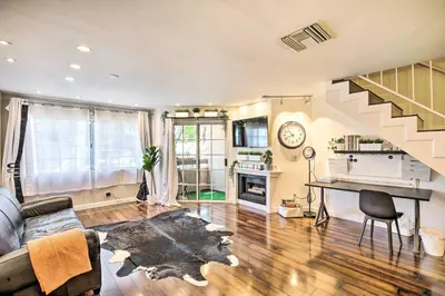 a living room with a couch and a staircase at 2 Mi to Griffith Park! Burbank Extended-Stay Condo in Burbank