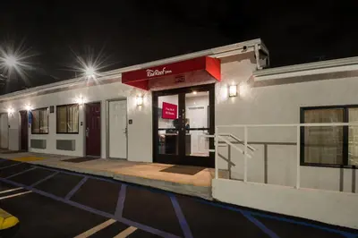a building with a sign on the side of it at night at Red Roof Inn Carson - Wilmington, CA in Wilmington