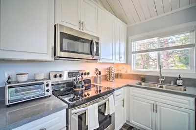 a kitchen with white cabinets and a stove top oven at Chic Running Springs Forest Cabin with Deck! in Running Springs