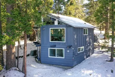 a blue tiny house in the snow at Chic Running Springs Forest Cabin with Deck! in Running Springs