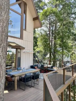 a patio with a table and chairs on a deck at Stunning LAKE VIEW Game Room Spa Walk To Village in Lake Arrowhead