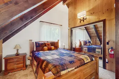 a bedroom with two beds and a large mirror at Retro Cabin in Lake Arrowhead