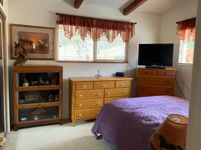 a bedroom with a bed and a dresser and a television at Kernville - walk to River Kern & Downtown in Kernville