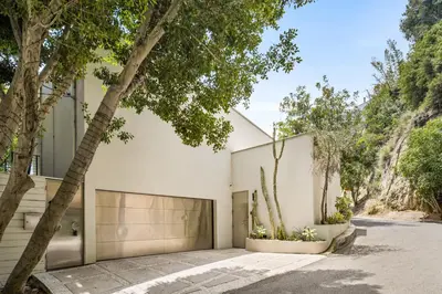 a white house with trees in front of it at The Hollywood Hills Crest Villa in Los Angeles