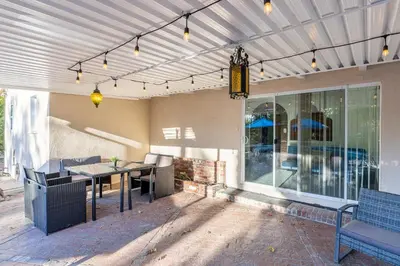 a patio with a table and chairs and a building at Spacious Home with Garden & Pool in Northridge