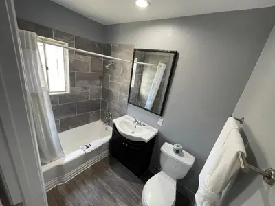 a bathroom with a sink and a toilet and a bath tub at Cornett Motel in Los Angeles