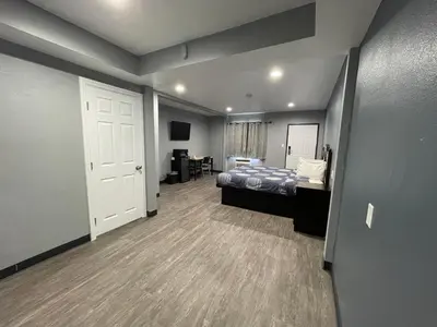 a bedroom with a bed and a room with a door at Cornett Motel in Los Angeles