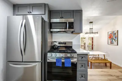 a kitchen with a stainless steel refrigerator and a stove at Red Cottage Charmer in Lake Arrowhead