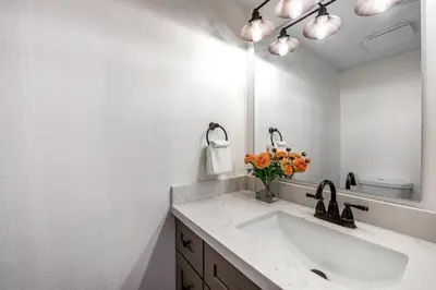 a white bathroom with a sink and a mirror at Red Cottage Charmer in Lake Arrowhead