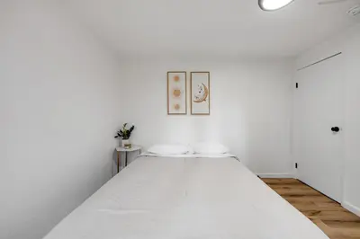 a white bedroom with a large white bed at Red Cottage Charmer in Lake Arrowhead