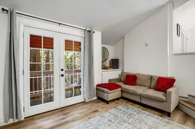 a living room with a couch and a window at Red Cottage Charmer in Lake Arrowhead