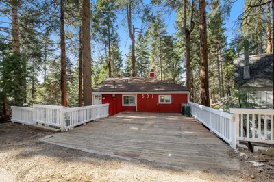 a red shed with a ramp in the woods at Red Cottage Charmer in Lake Arrowhead