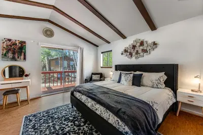 a bedroom with a bed and a desk and a window at Blue Bird Beauty in Running Springs