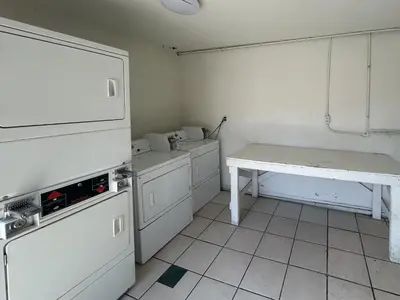 a kitchen with white appliances and a table in it at Motel 6 Buena Park, CA Anaheim Near Maingate Knotts in Buena Park
