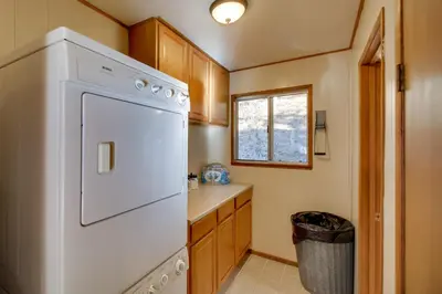 a kitchen with a white refrigerator and a window at Peaceful and Idyllic Forest Cabin with Pool Table in Pine Mountain Club