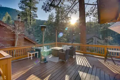 a wooden deck with a table and chairs on it at Peaceful and Idyllic Forest Cabin with Pool Table in Pine Mountain Club